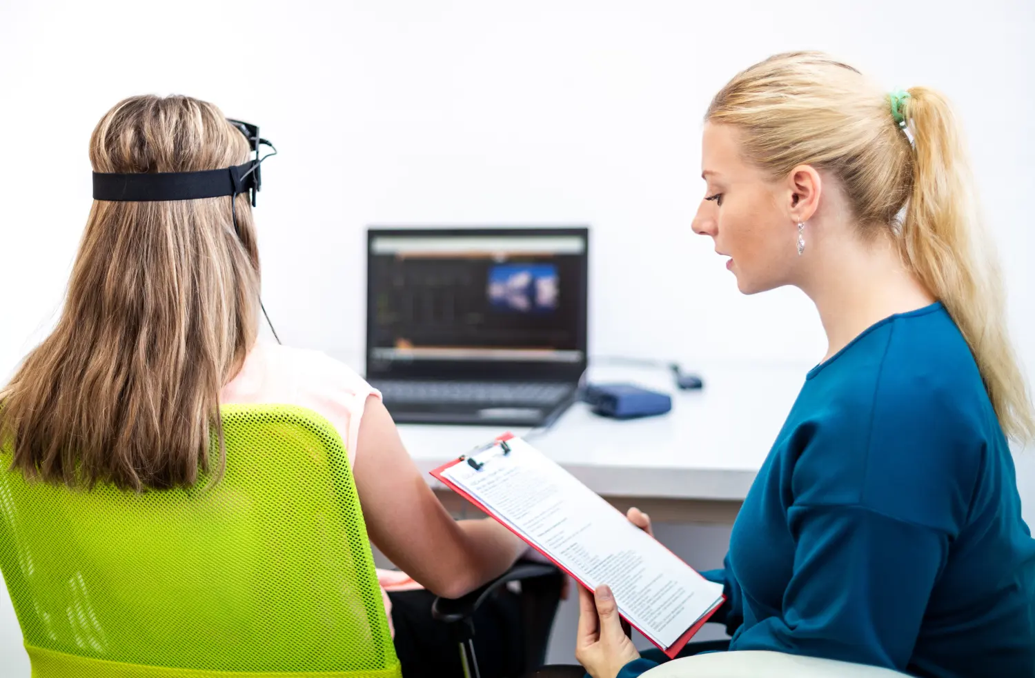 Junge Teenagerin und Kindertherapeutin während einer EEG-Neurofeedback-Sitzung